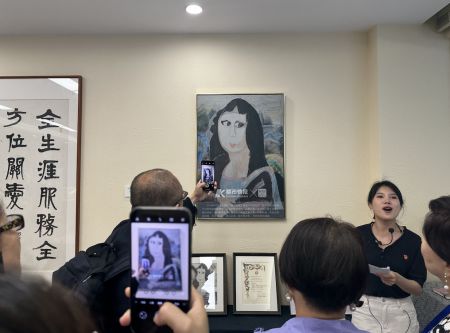 海外华文媒体代表们在孤独症女孩吴双源的“萌版”《蒙娜丽莎》前拍照留念。