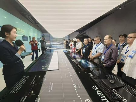 海外华文媒体代表走进西山居展厅，工作人员向媒体代表们分享介绍。（谢明 摄）