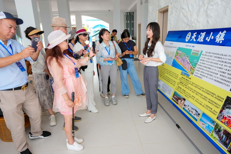三亚市天涯区旅游和文化广电体育局副局长华岸向参访的海外华文媒体介绍天涯小镇的旅游资源。中新网记者 骆云飞 摄